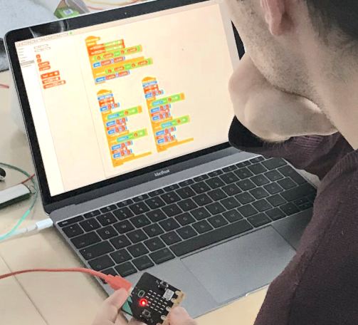 Hands connecting wires to a board